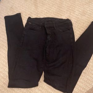 Gold sign black jeans